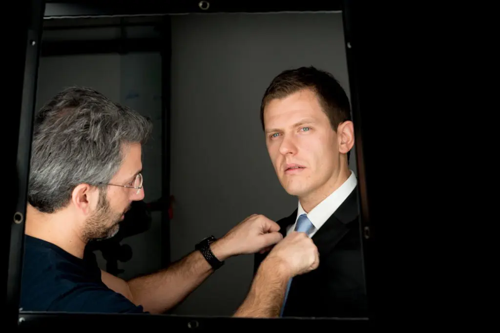 Photographe ajustant une tenue avant un portrait professionnel